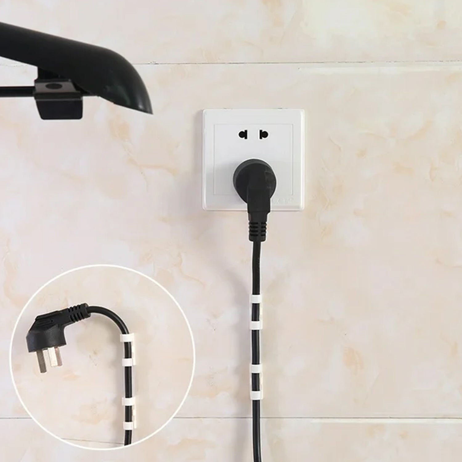 A single plastic cable clip securing a charging cable on a desk, demonstrating effective cord management.