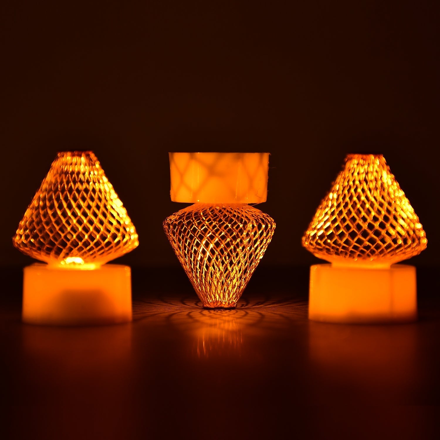 A close-up view of multiple Flameless LED Tea Light Candles glowing warmly on a dark surface.