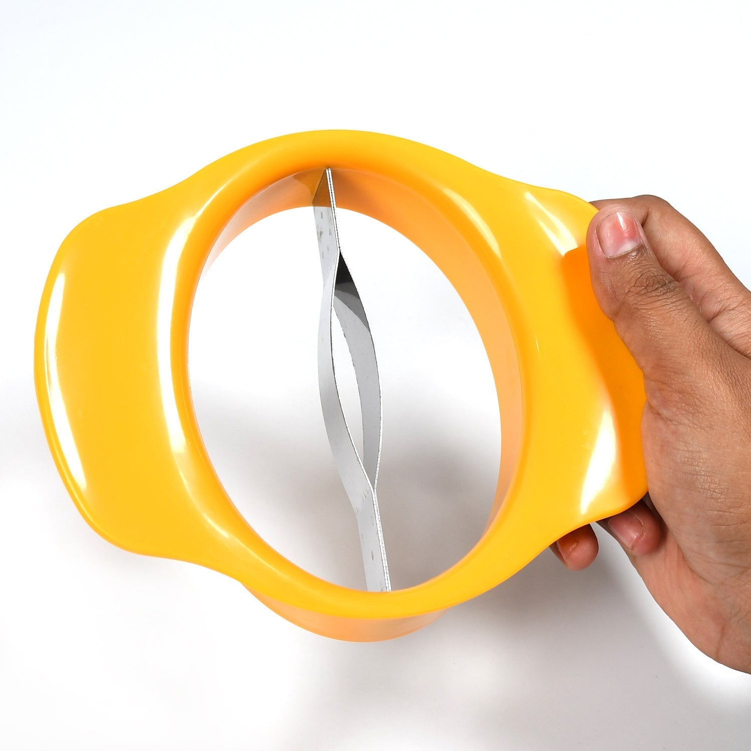 Hand holding the mango slicing tool over a mango, demonstrating its ergonomic design.