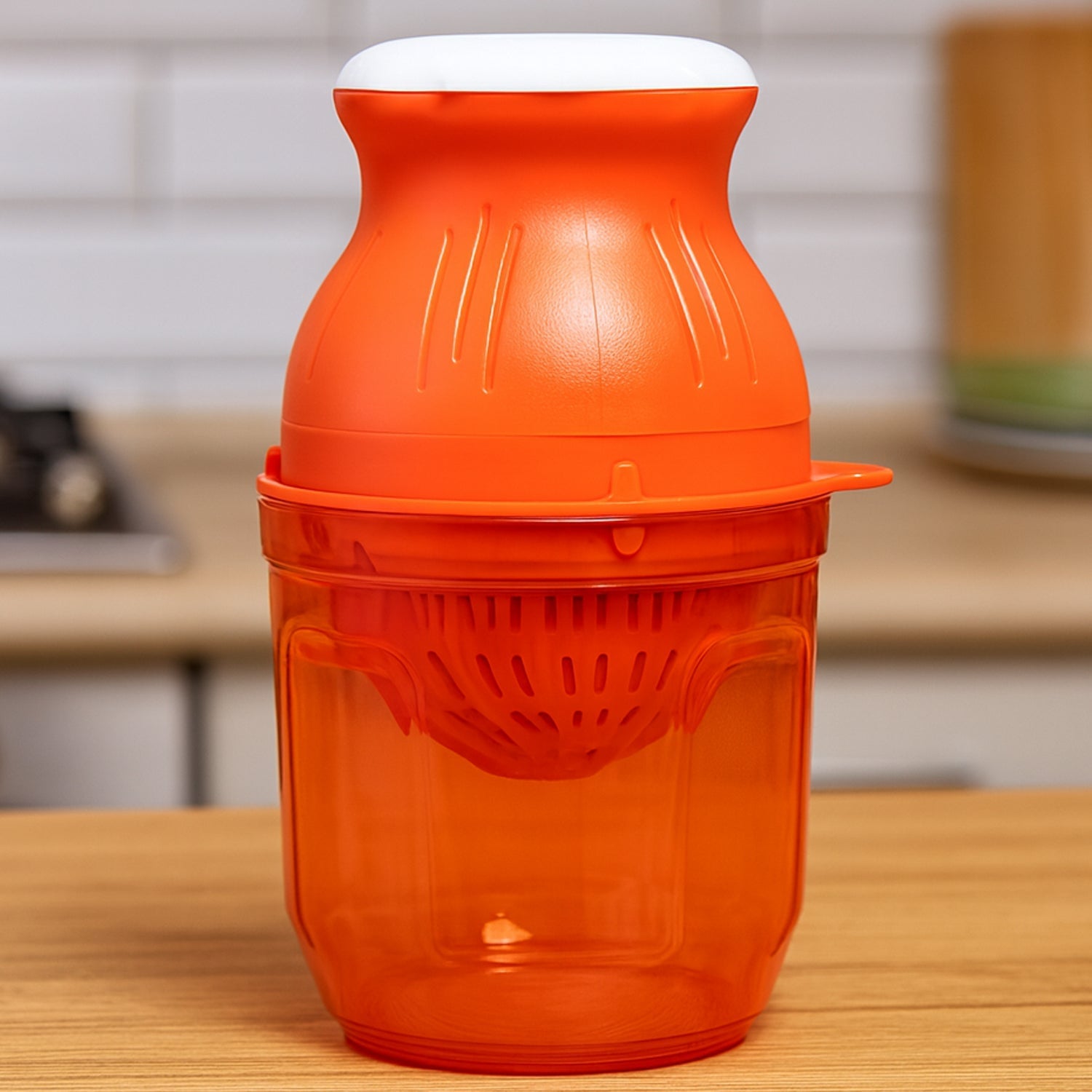 Portable handheld manual juicer showing transparent container with fresh juice