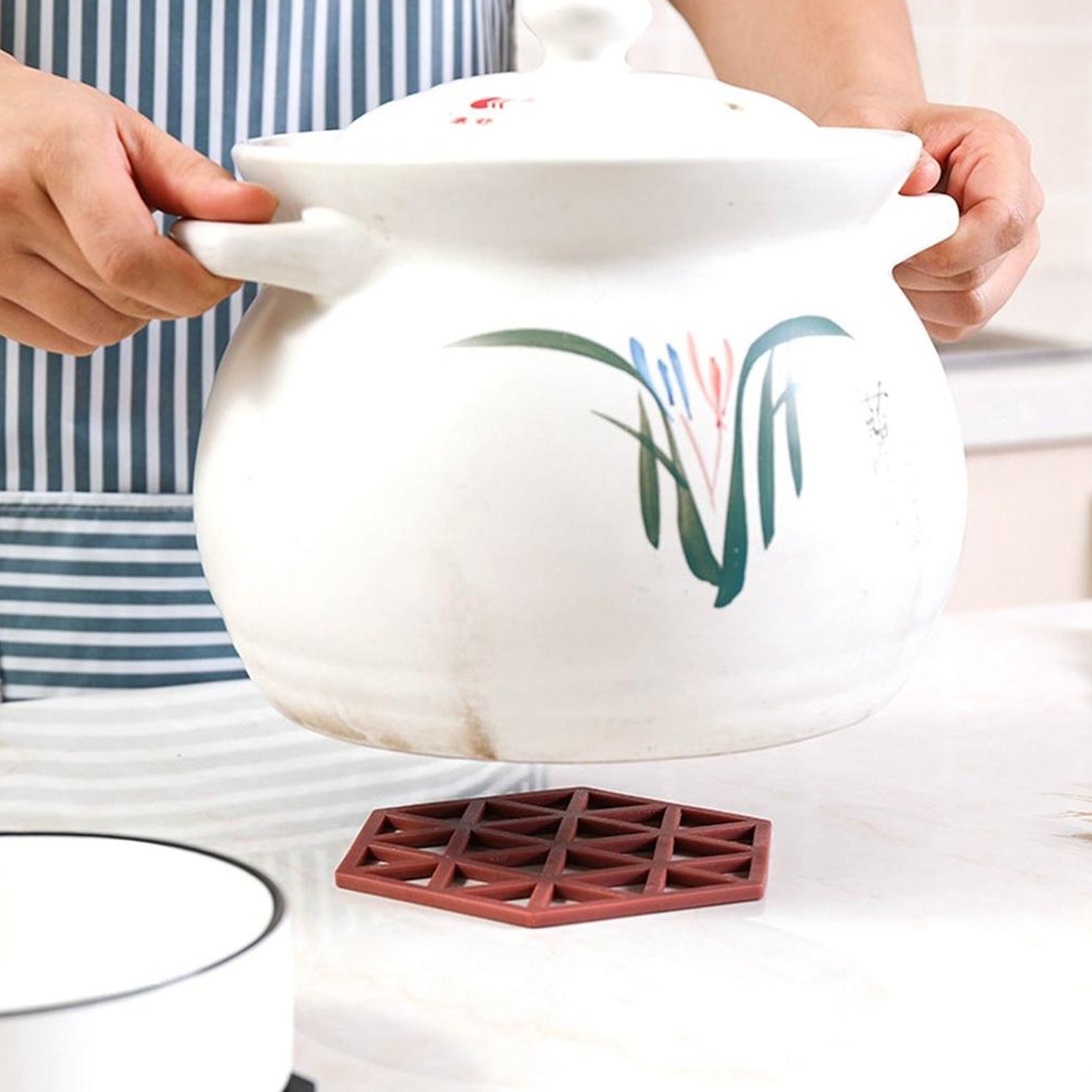 Hollow design PVC mat used as a heat-resistant pot placemat in a kitchen.