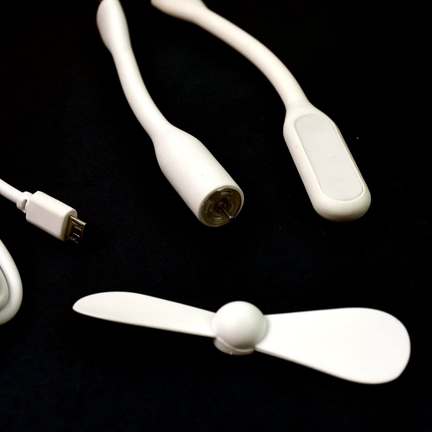 A mini USB fan plugged into a laptop, demonstrating its convenient use for personal cooling.