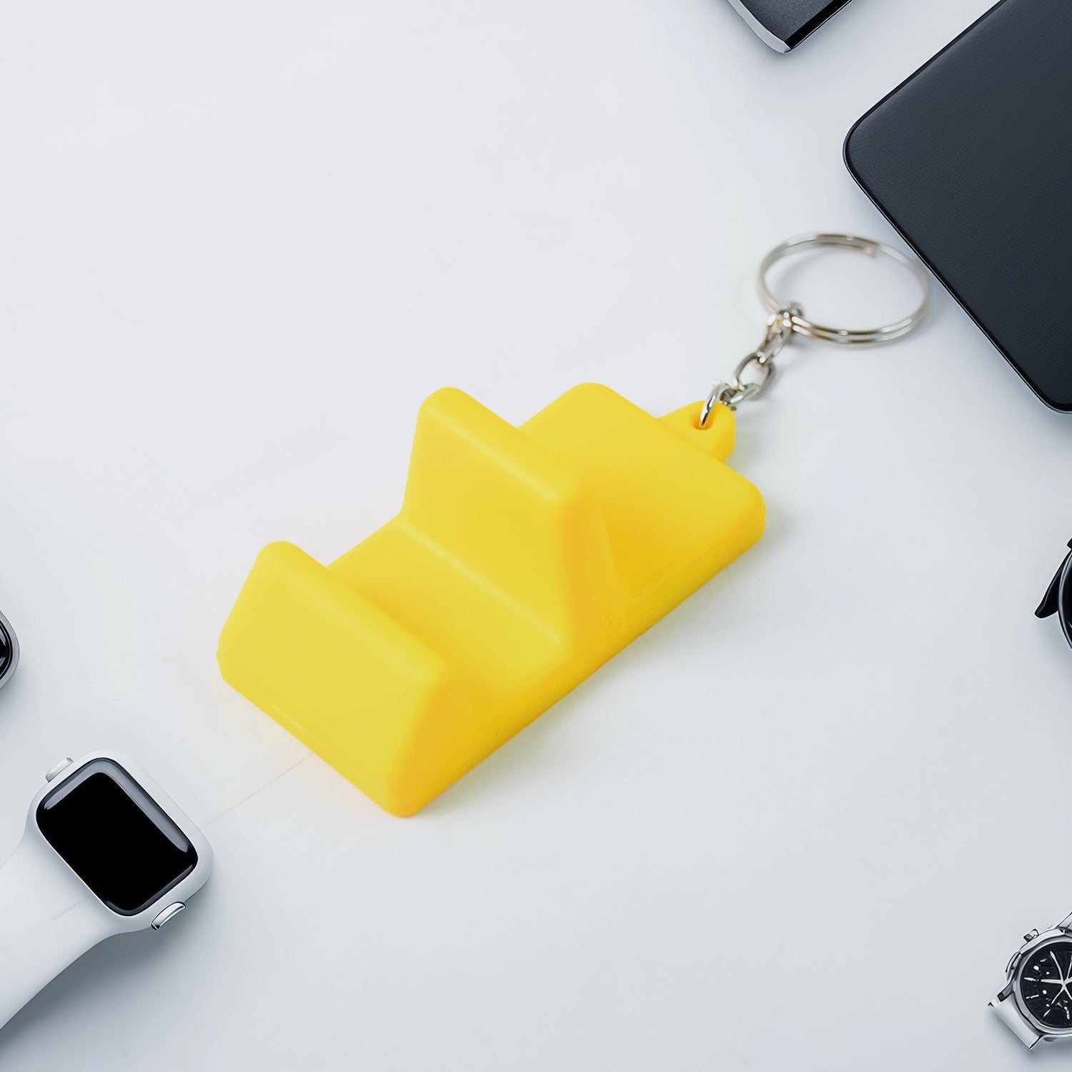Mobile stand keychain held on finger showing compact size