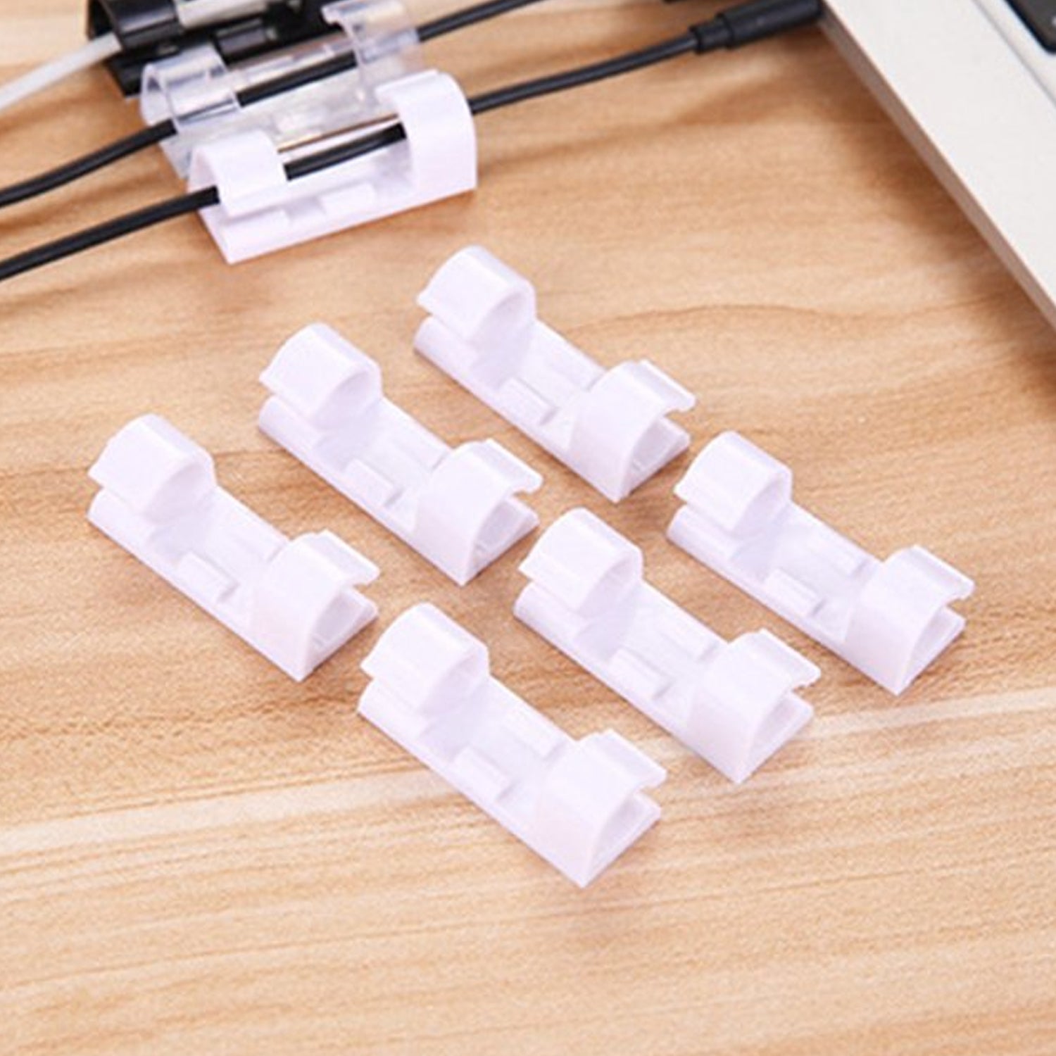 A set of white plastic cable clips with strong adhesive backing displayed on a clean surface.