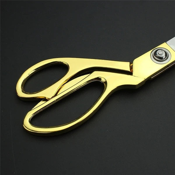 Ergonomic stainless steel tailoring scissors with golden accents.