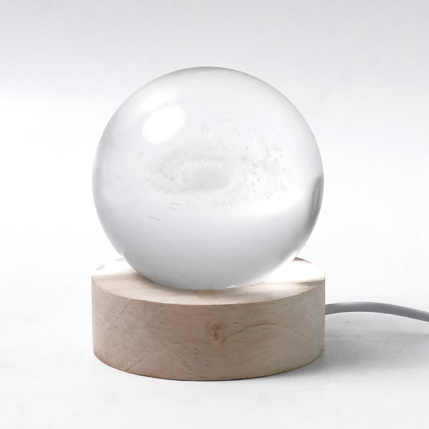 Hand holding the crystal sphere of the 3D Crystal Ball Lamp highlighting craftsmanship.