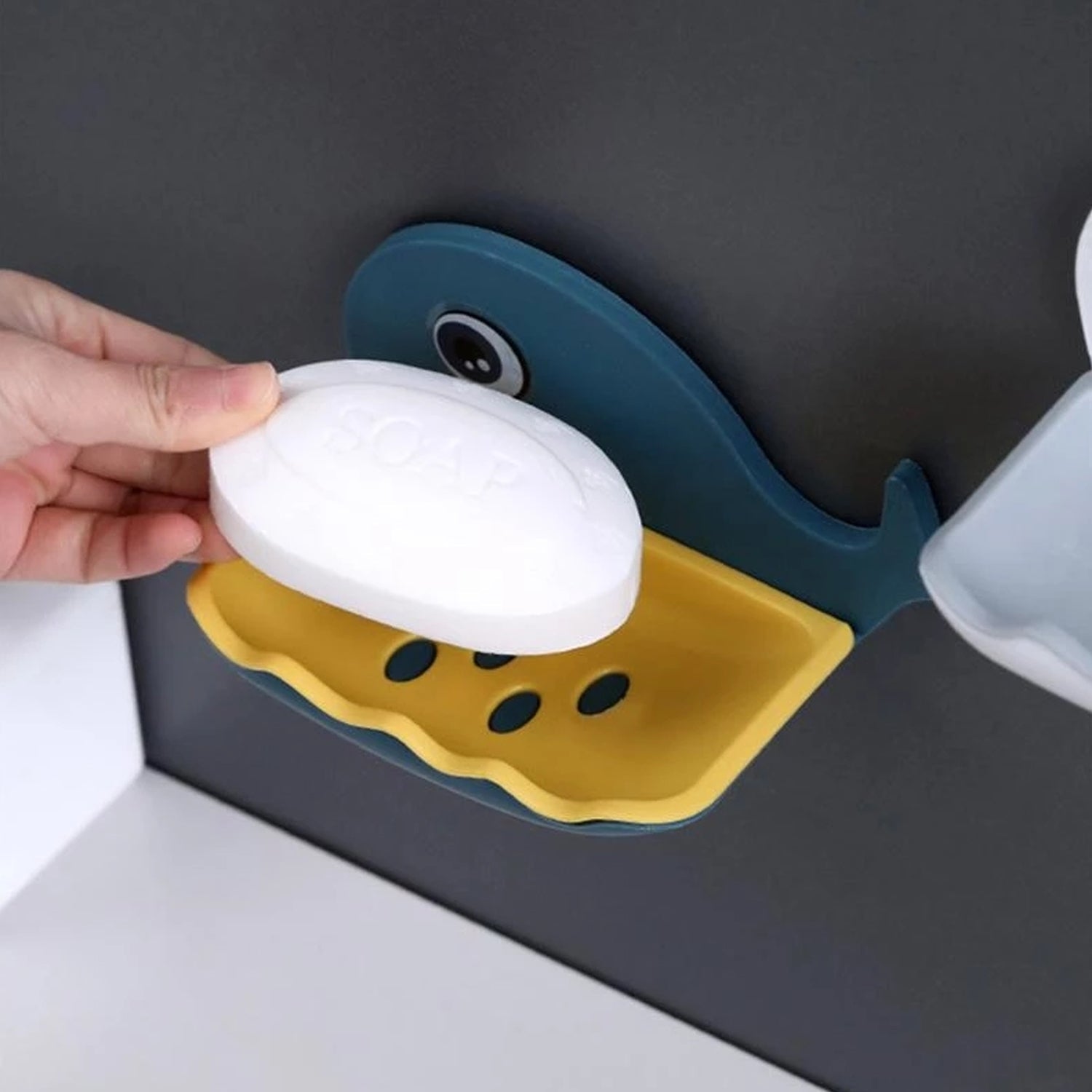 Fish-shaped wall mounted soap holder in a modern bathroom setting.