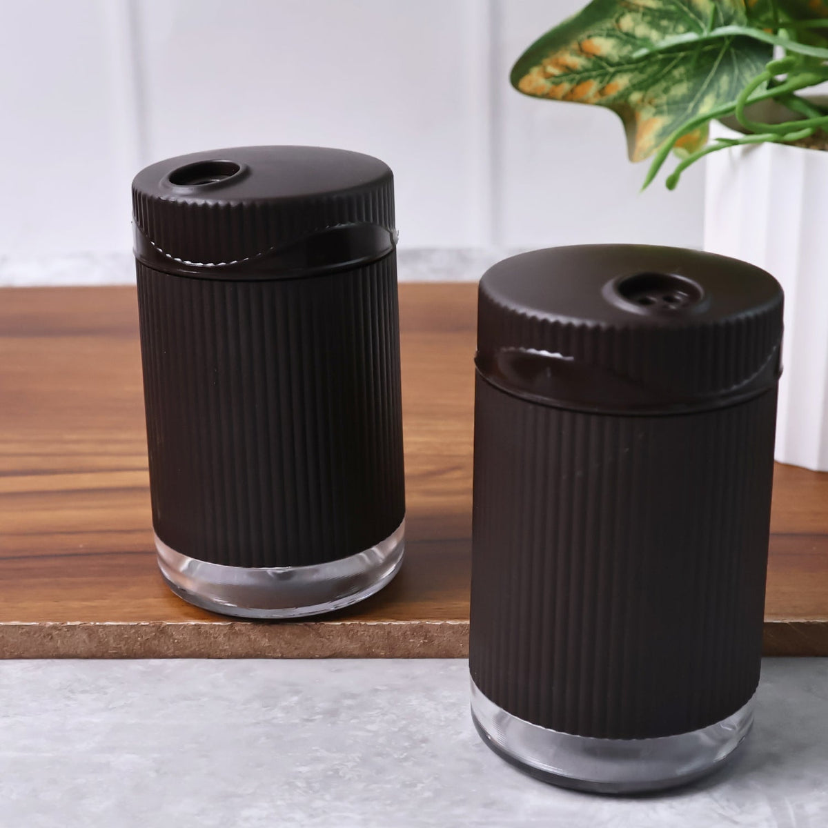 Supermom Linoo salt and pepper dispensers held in hand showing size and grip