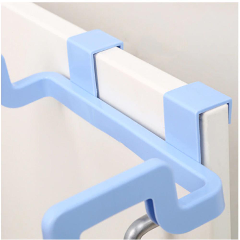Plastic garbage bag holder conveniently attached to a kitchen cabinet door.