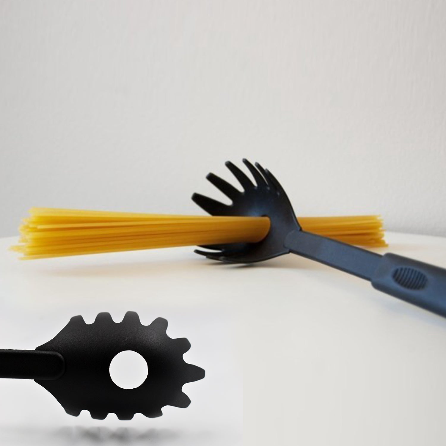 Black heat-resistant pasta server scooping spaghetti from a pot, showcasing its non-stick design.