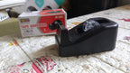 The VoltDesk tape dispenser in its original product packaging, displayed on a clean surface.