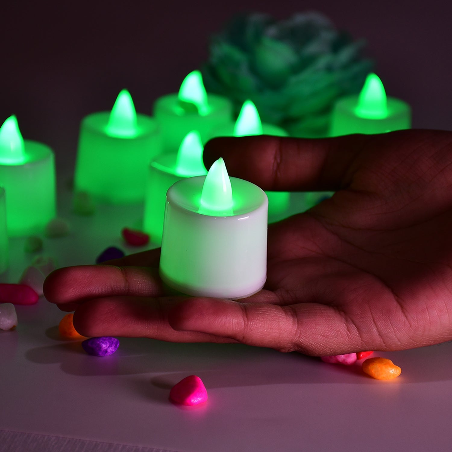 Green LED tealight candles scattered for home decoration, showing their gentle flicker.