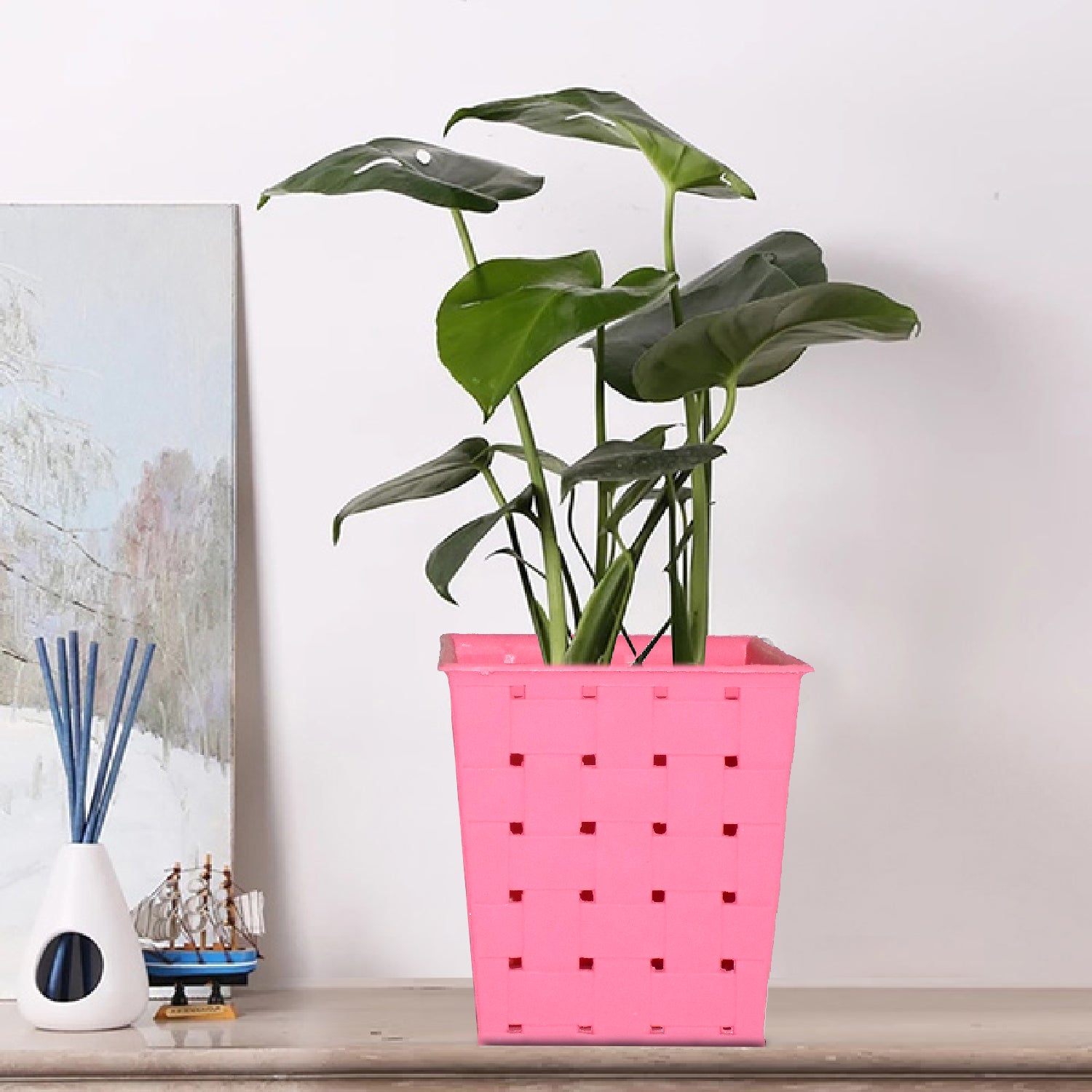 Square dotted railing planter for a single plant, enhancing a modern balcony.