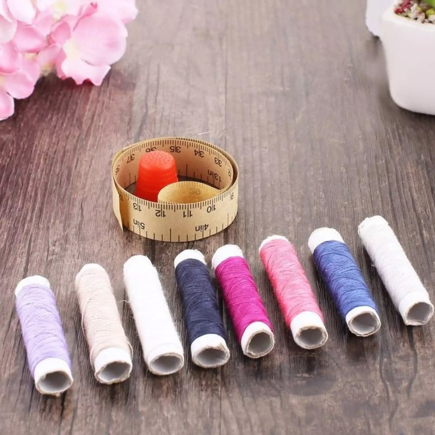 A sewing box neatly arranged with colorful spools of thread and small notions.