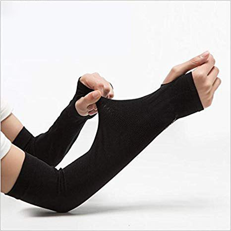 Athlete cycling outdoors wearing black sports arm sleeves, demonstrating active use.