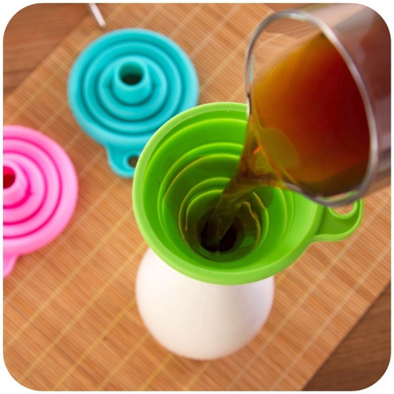 Collapsible silicone funnel in red, ready for kitchen use.