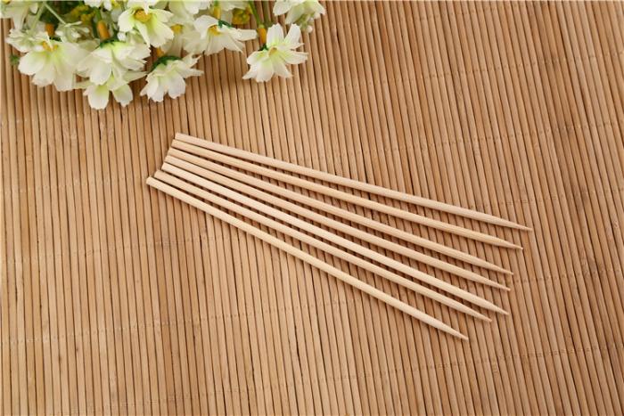 Variety of grilled meat and vegetables on long bamboo kebab sticks.