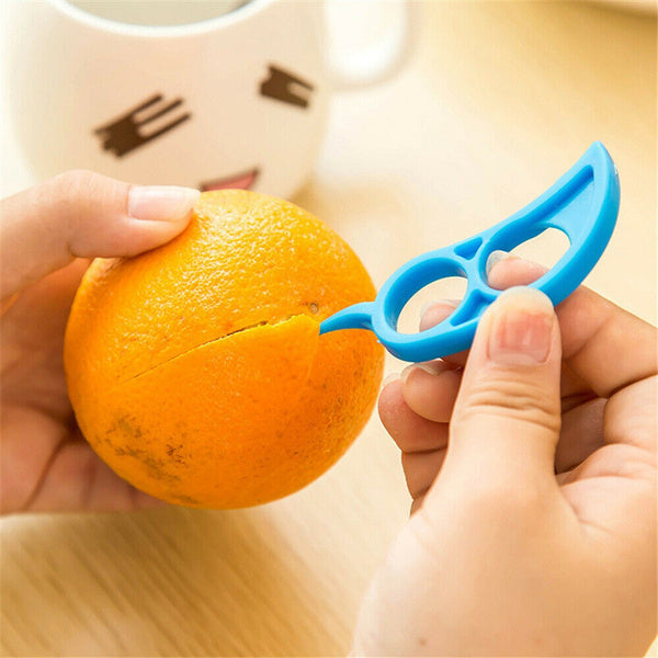A bright orange being peeled with the Snail Orange Peeler, highlighting its mess-free capability.