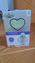 A child holding the Feedora plastic baby feeding bottle with handles, ensuring a firm grip.