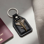 Top view of leather finish keychain featuring metal fighter jet emblem
