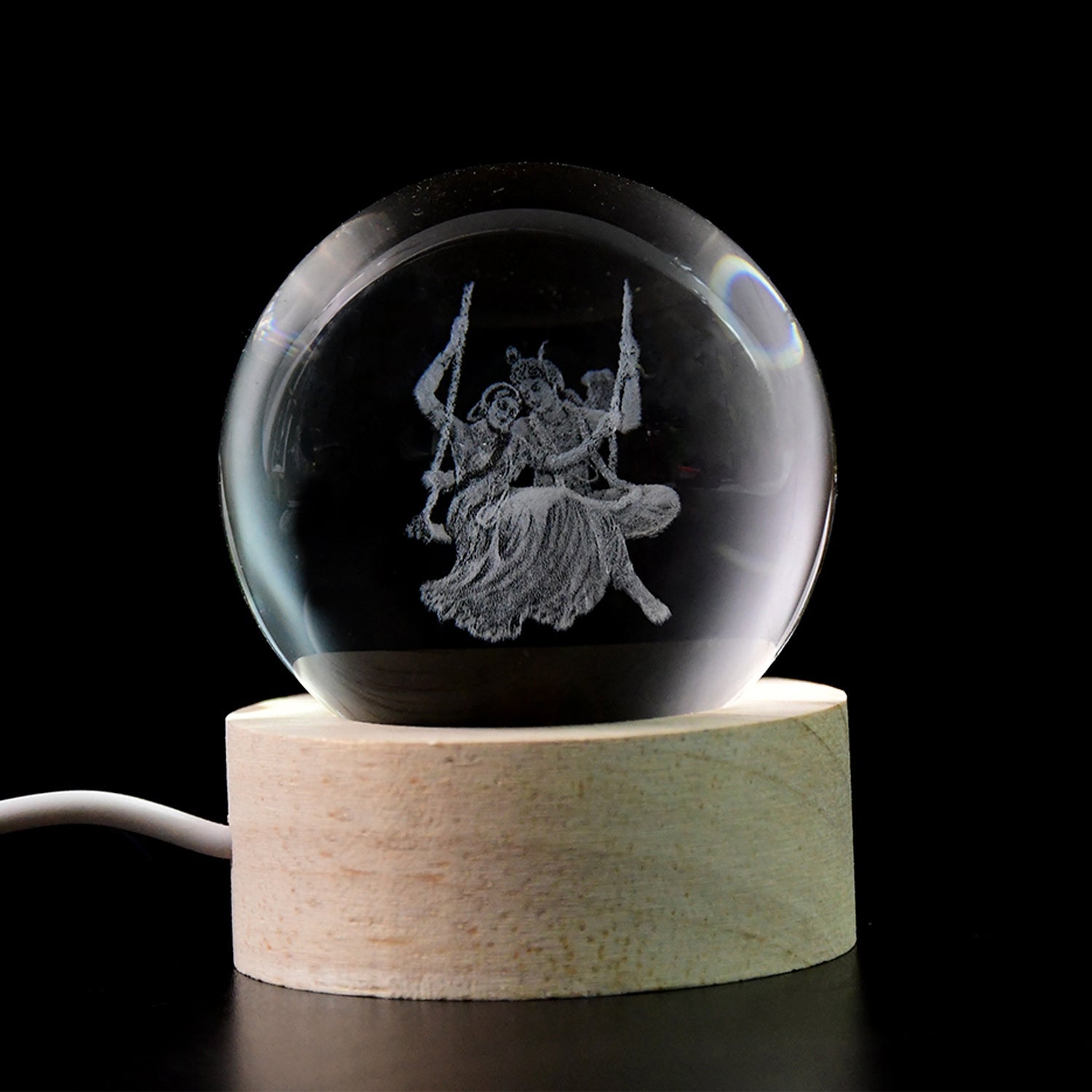 The intricate design of the Radha Krishna idol within the crystal ball night light.