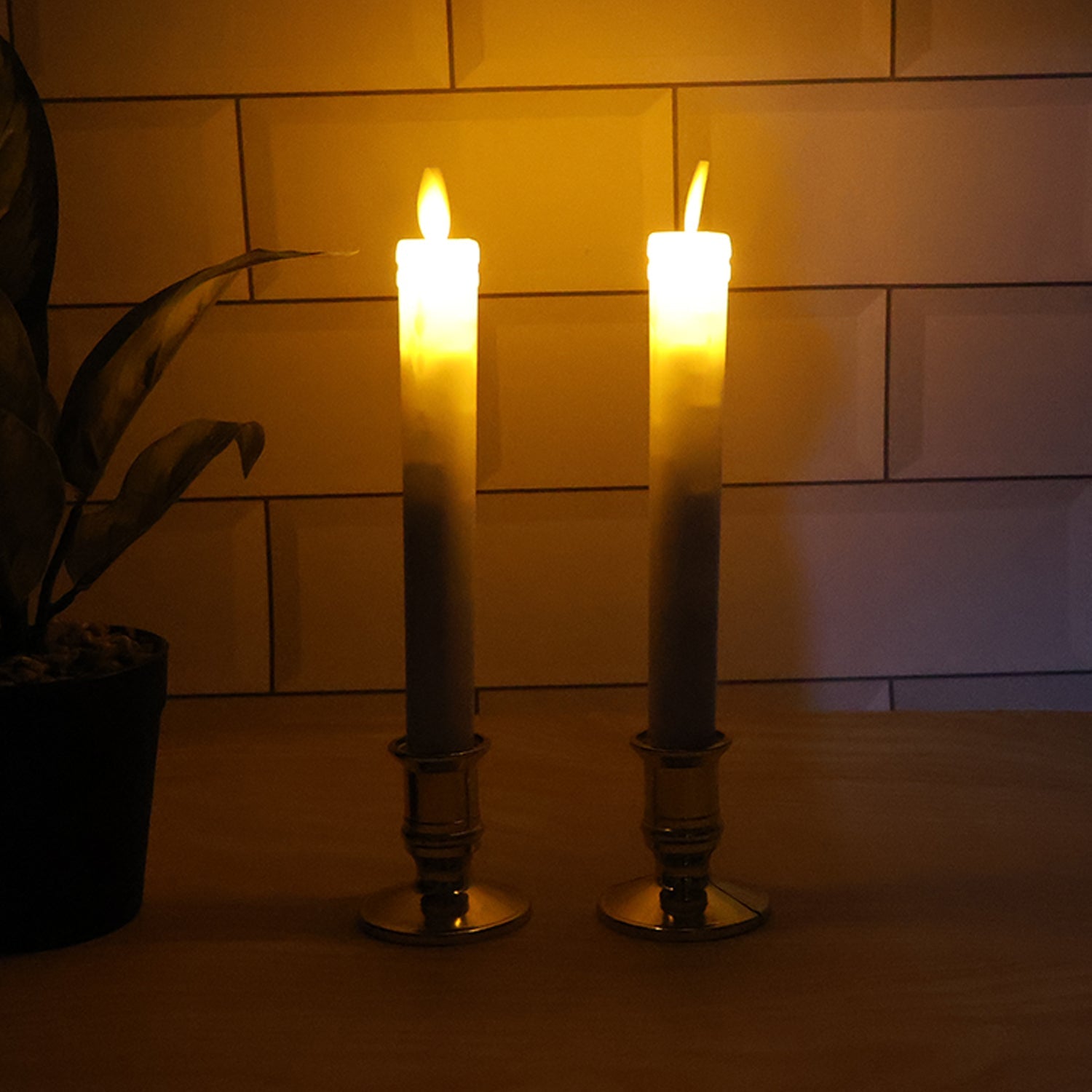 Pair of battery operated flameless LED taper candles glowing warmly during festival celebration
