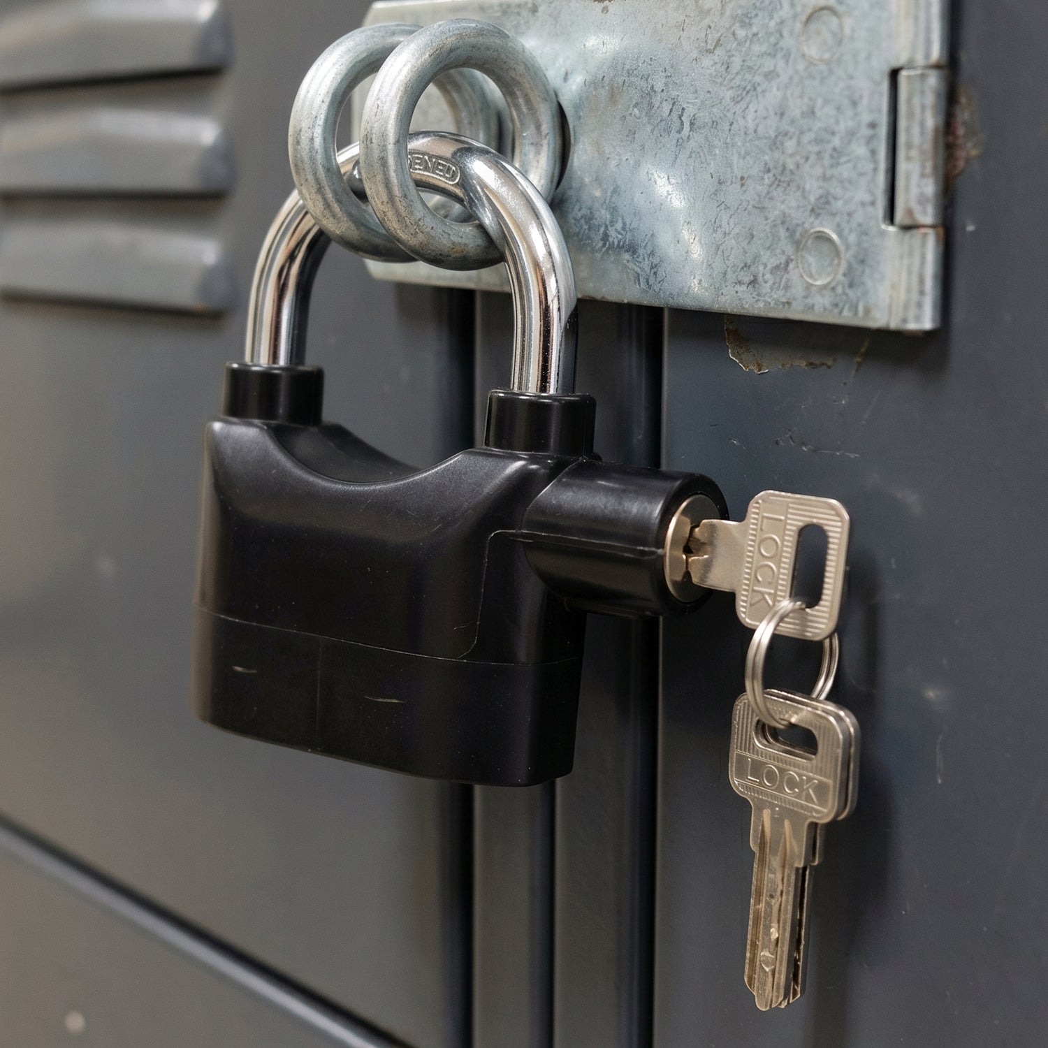 Safora Security Alarm Padlock securing a sturdy metal gate, demonstrating its anti-theft use.