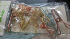 Lifestyle shot of sturdy stainless steel clips being used to hang clothes on a line.
