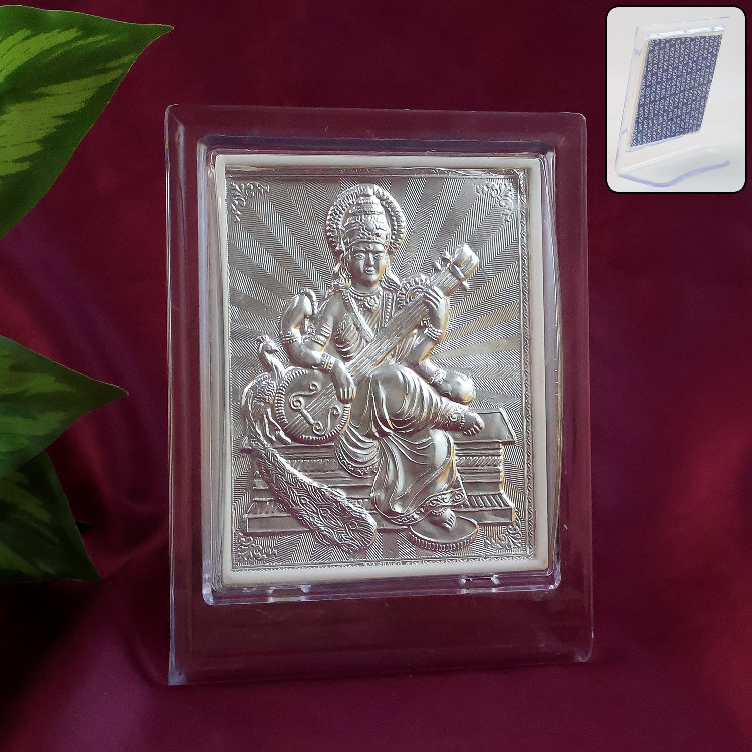Silver Saraswati Maa photo frame with stand placed on a white surface