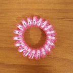 Group of mixed color spiral hair ties on a white background