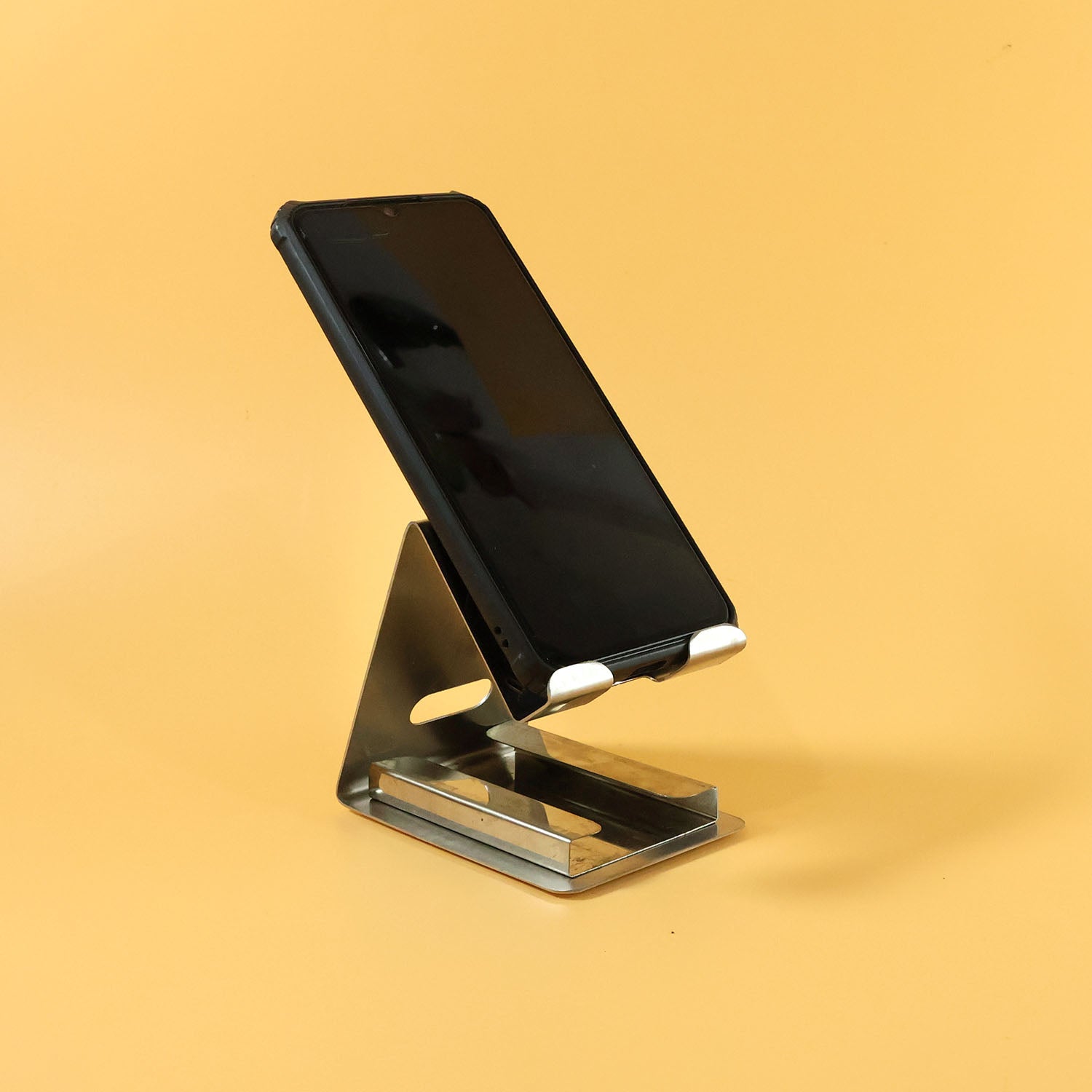 Metal mobile phone stand holder showing angled view with phone